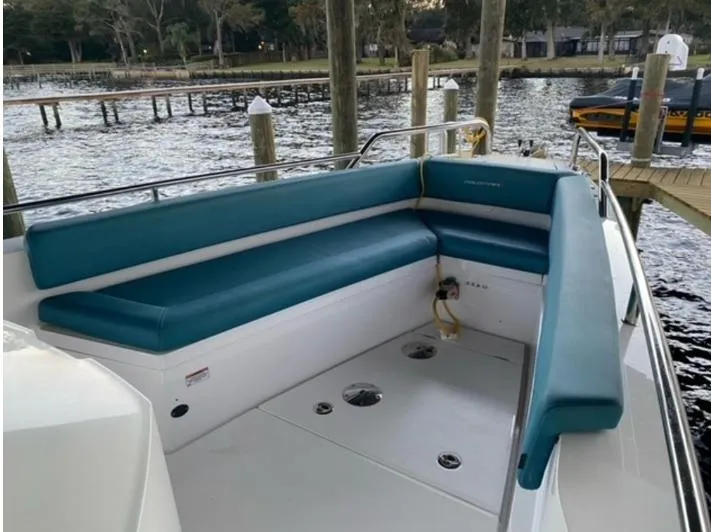 Slide: The Image of 2020 Axopar 28 boat with teal seating, docked by a serene waterfront. - 48