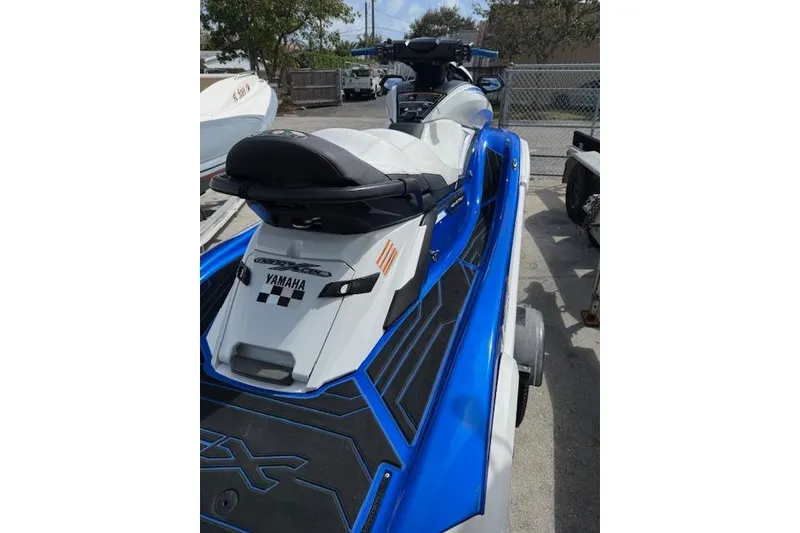 Slide: The Image of 2021 Yamaha WaveRunner FX Cruiser HO in blue and white, parked outdoors. - 6