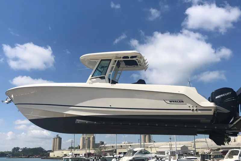 Slide: The Image of 2016 Boston Whaler 280 Outrage boat lifted at marina, clear sky background. - 3