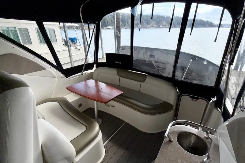 Slide: The Image of 2007 Sea Ray Sundancer 310 interior with seating, table, and lake view. - 19