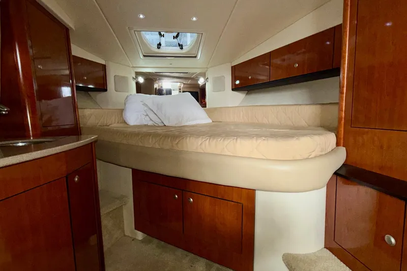 Slide: The Image of 2007 Sea Ray Sundancer 310 cabin interior with bed, wood cabinets, and skylight. - 20