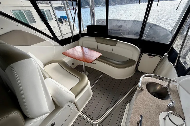Slide: The Image of 2007 Sea Ray Sundancer 310 interior with seating, table, and sink, overlooking water. - 8