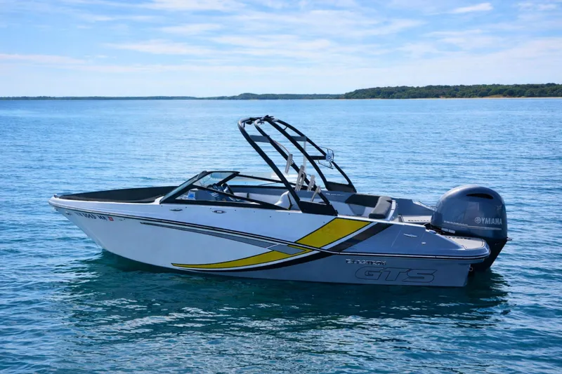 The Image of 2020 Glastron GTS 200 boat on calm blue water, featuring sleek design and Yamaha engine. - 0