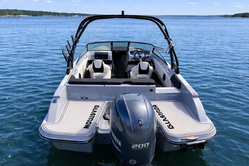 Slide: The Image of 2020 Glastron GTS 200 boat on calm blue water, rear view with Yamaha engine. - 3