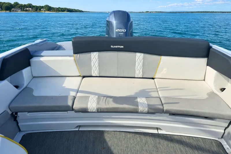 Slide: The Image of 2020 Glastron GTS 200 boat interior with cushioned seating on a sunny day. - 4