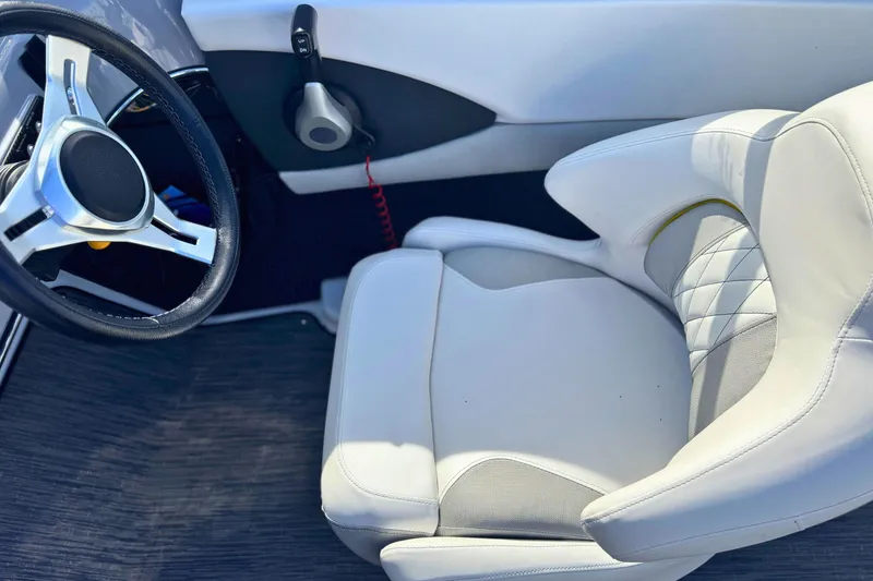 Slide: The Image of 2020 Glastron GTS 200 boat interior with steering wheel and white seat. - 7