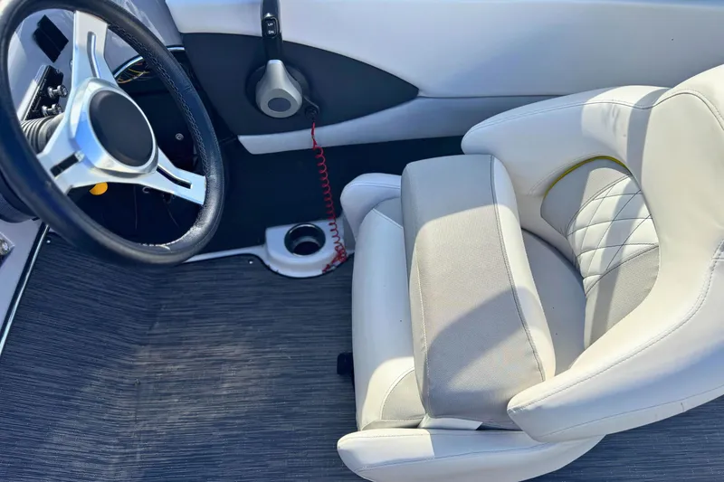Slide: The Image of 2020 Glastron GTS 200 boat interior with steering wheel and white seating. - 8