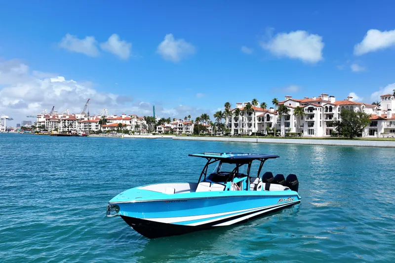 The Image of 2025 Nor-Tech 340 Sport Center Console boat on blue water near luxury waterfront buildings. - 1
