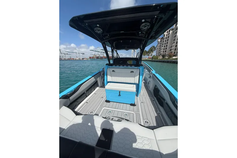 Slide: The Image of 2025 Nor-Tech 340 Sport Center Console boat on water, featuring sleek design and spacious deck. - 11