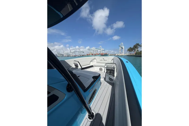 Slide: The Image of 2025 Nor-Tech 340 Sport Center Console boat on water, clear sky, industrial background. - 14