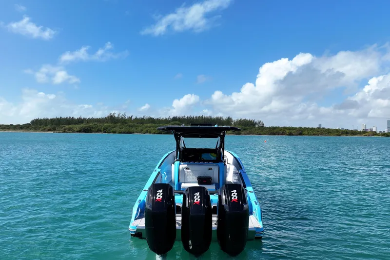 Slide: The Image of 2025 Nor-Tech 340 Sport Center Console boat on clear blue water under a sunny sky. - 3