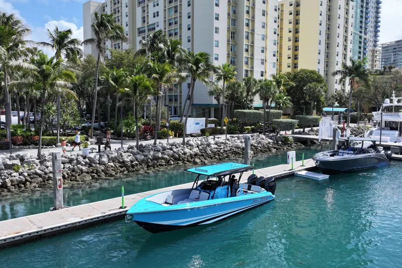 Slide: The Image of 2025 Nor-Tech 340 Sport Center Console docked in a tropical marina setting. - 4