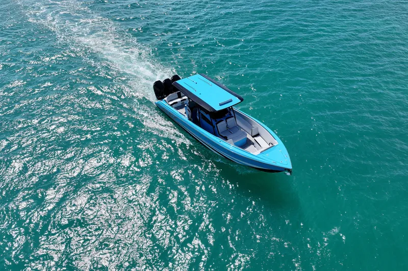 Slide: The Image of 2025 Nor-Tech 340 Sport Center Console cruising on clear blue water. - 5