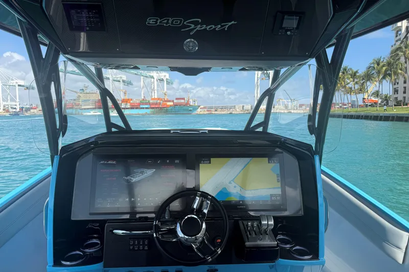 Slide: The Image of 2025 Nor-Tech 340 Sport Center Console dashboard with navigation screens, steering wheel, and ocean view. - 6