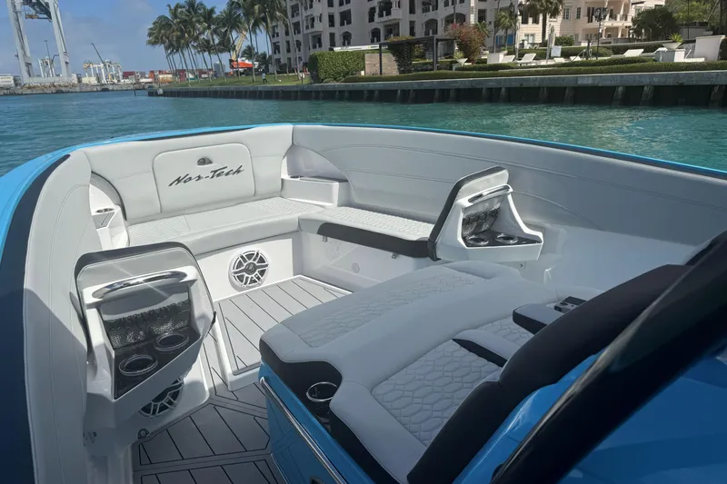Slide: The Image of 2025 Nor-Tech 340 Sport Center Console boat interior with luxurious seating and waterfront view. - 8