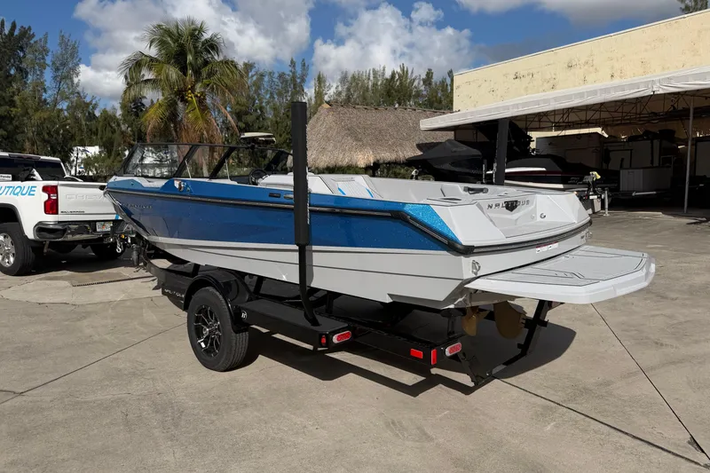 Slide: The Image of 2026 Nautique Ski Nautique boat on trailer, blue and white design, parked outdoors. - 5