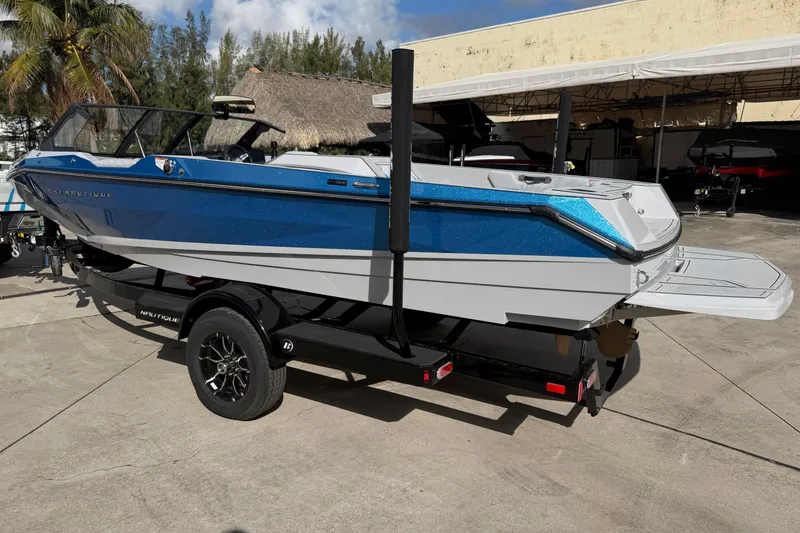 Slide: The Image of 2026 Nautique Ski Nautique boat on trailer, blue and white design, parked outdoors. - 6