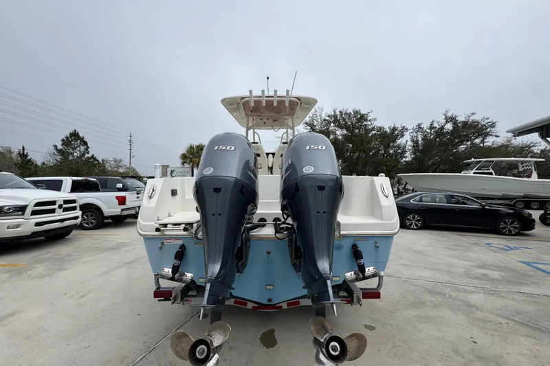 Slide: The Image of 2022 Sailfish 242 CC boat with dual 150 horsepower engines in a parking lot. - 10