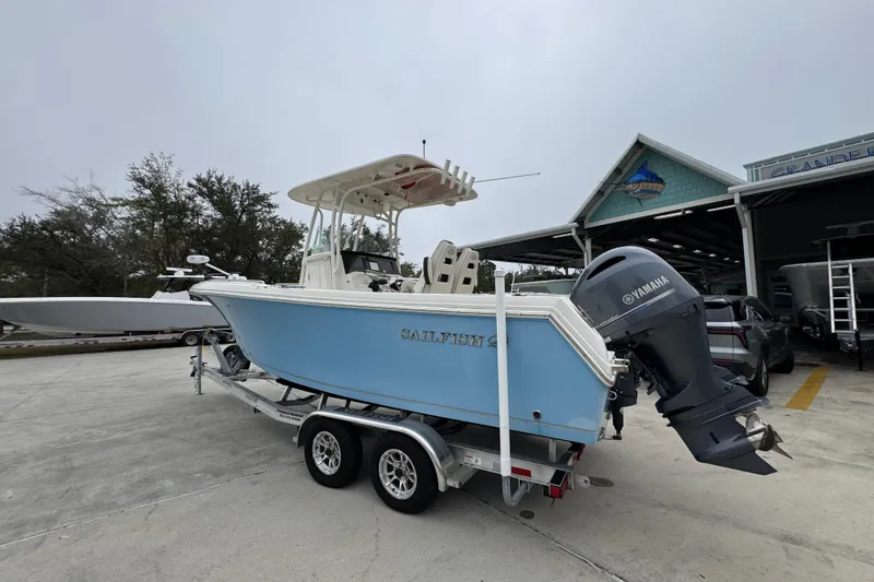 Slide: The Image of 2022 Sailfish 242 CC boat with Yamaha engine on trailer, parked outside a marine shop. - 13