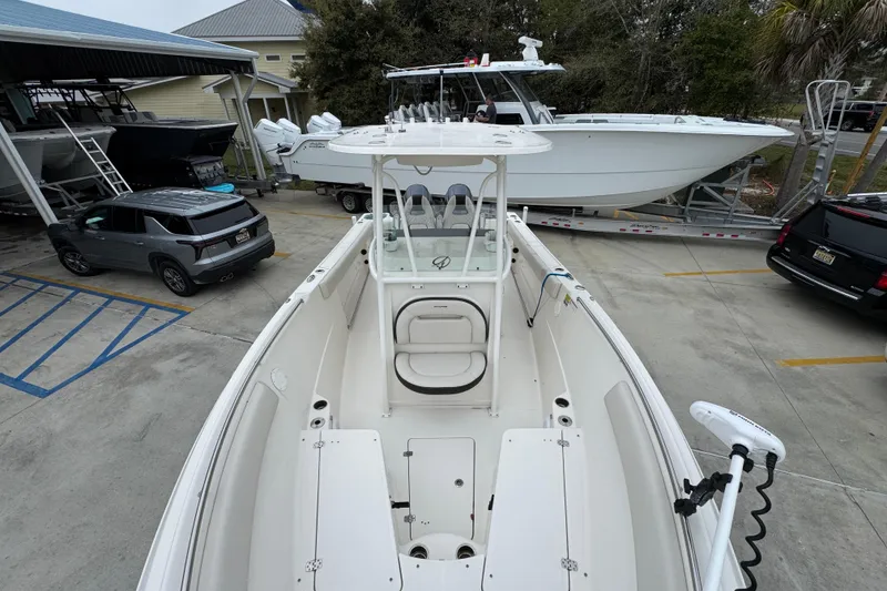 Slide: The Image of 2022 Sailfish 242 CC boat in a parking lot, surrounded by vehicles and other boats. - 19