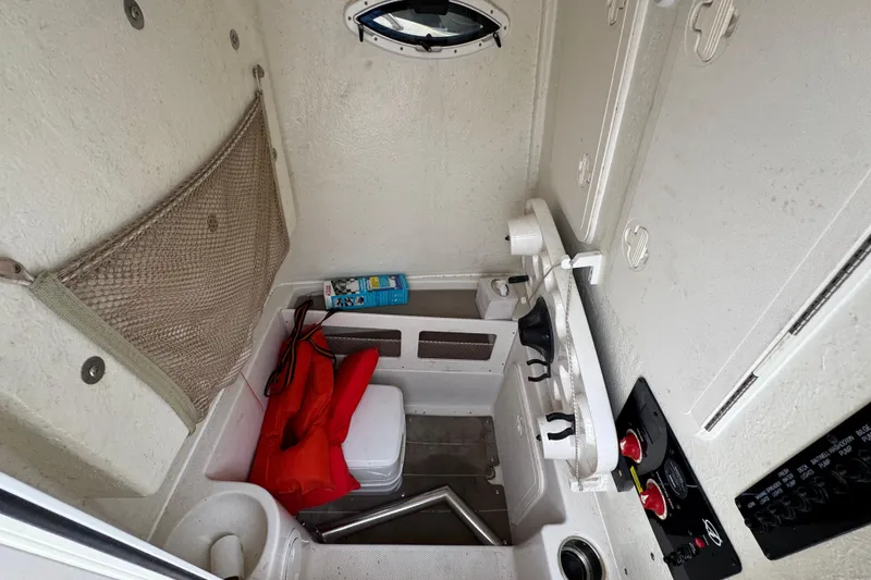 Slide: The Image of 2022 Sailfish 242 CC boat interior with storage, life jacket, and control panel. - 23