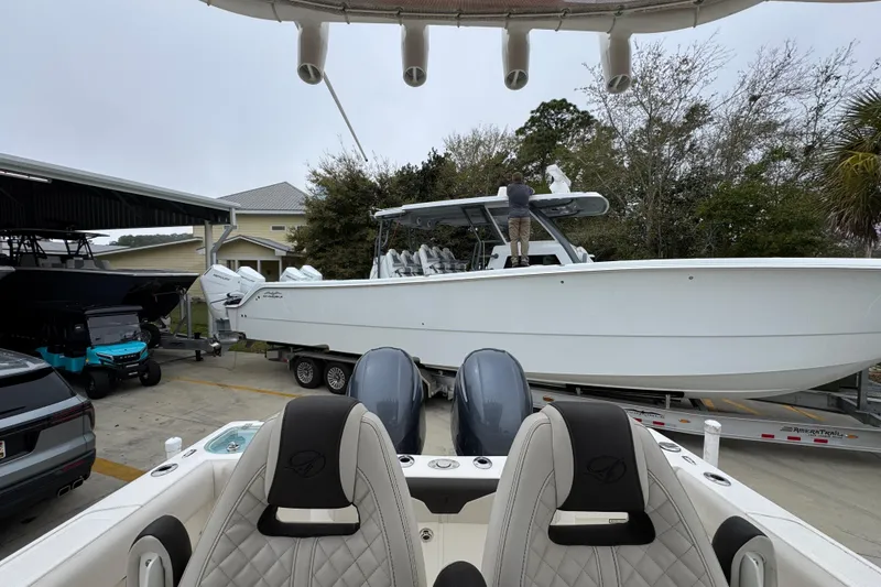 Slide: The Image of 2022 Sailfish 242 CC boat on trailer, parked outdoors near other vehicles. - 26