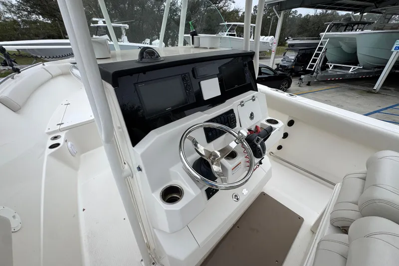 Slide: The Image of 2022 Sailfish 242 CC boat cockpit with steering wheel and navigation controls. - 28
