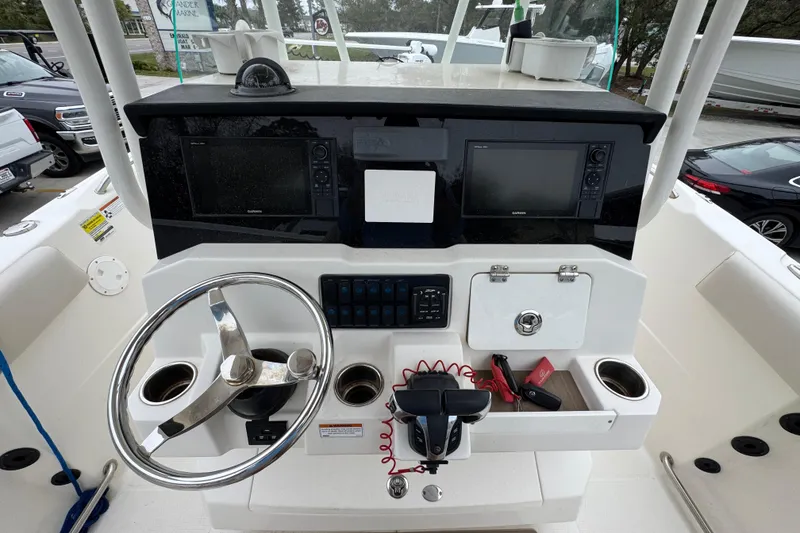 Slide: The Image of 2022 Sailfish 242 CC boat dashboard with steering wheel and navigation equipment. - 29