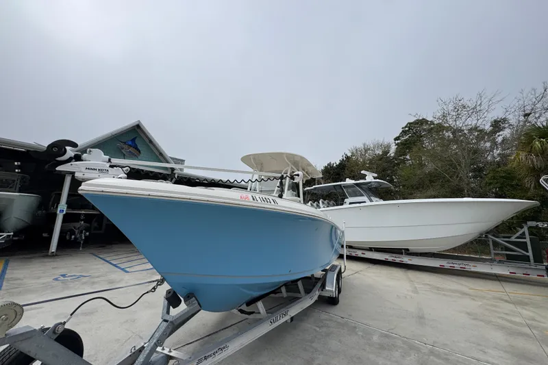 Slide: The Image of 2022 Sailfish 242 CC boat on trailer, parked outdoors near a building. - 3