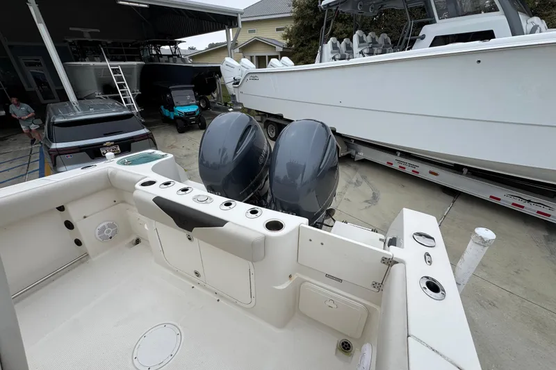Slide: The Image of 2022 Sailfish 242 CC boat with dual engines in a marina setting. - 36