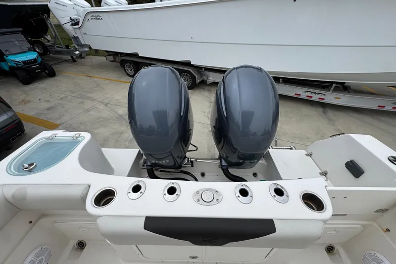 Slide: The Image of 2022 Sailfish 242 CC boat with dual outboard motors in a marina setting. - 37