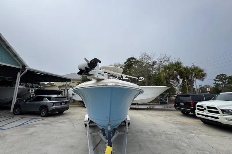 Slide: The Image of 2022 Sailfish 242 CC boat on trailer in parking lot, surrounded by vehicles. - 4