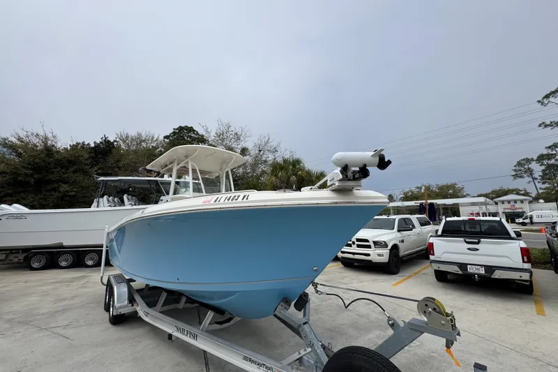 Slide: The Image of 2022 Sailfish 242 CC boat on trailer in parking lot, surrounded by vehicles. - 5