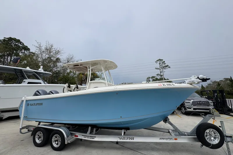 Slide: The Image of 2022 Sailfish 242 CC boat on trailer, light blue hull, parked outdoors. - 6