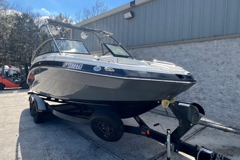 Slide: The Image of 2014 Yamaha Boats AR240 on trailer, parked outdoors near a building. - 1