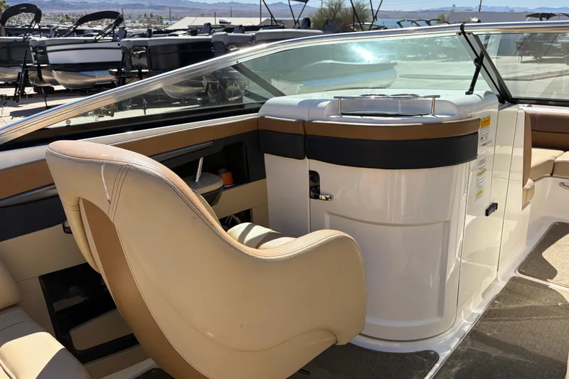 Slide: The Image of 2015 Sea Ray 220 Sundeck interior with beige seating and sleek dashboard design. - 10