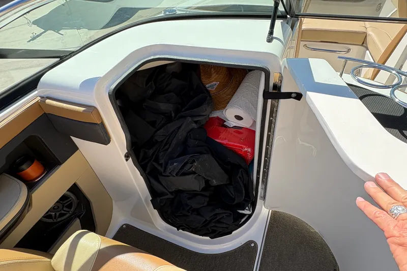 Slide: The Image of Storage compartment on a 2015 Sea Ray 220 Sundeck boat, containing various items. - 12