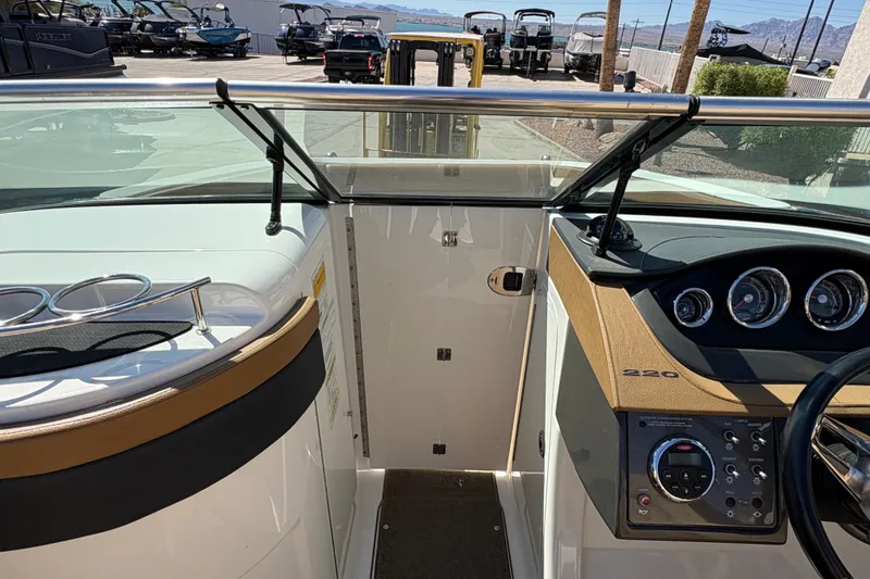 Slide: The Image of 2015 Sea Ray 220 Sundeck dashboard and controls, showcasing sleek design and instrumentation. - 17