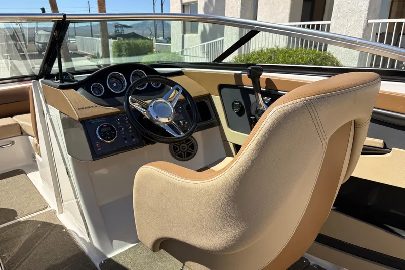 Slide: The Image of 2015 Sea Ray 220 Sundeck cockpit with steering wheel and control panel. - 9