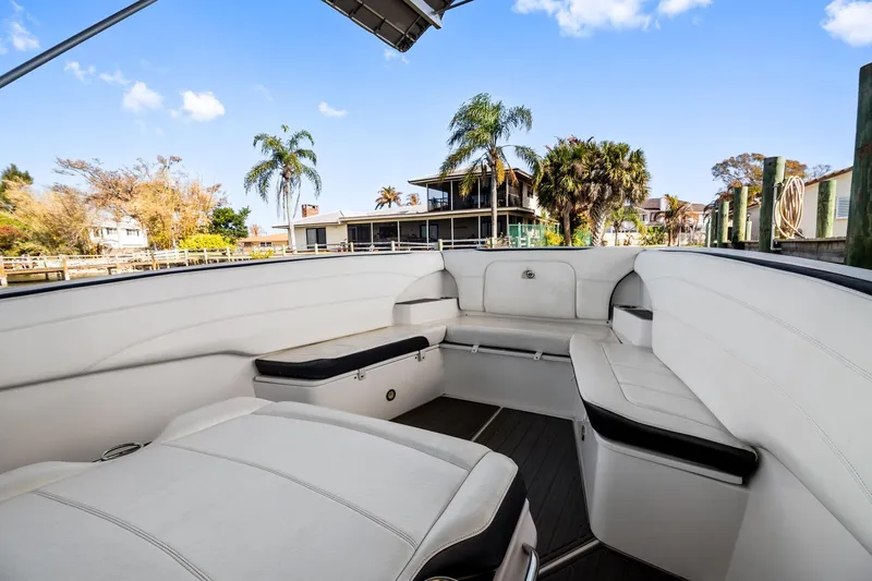 Slide: The Image of 2018 Nor-Tech 340 Sport Center Console boat interior with white seating and scenic waterfront view. - 10