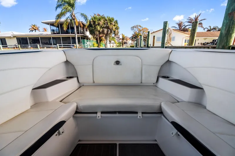Slide: The Image of 2018 Nor-Tech 340 Sport Center Console boat interior with white seating and waterfront view. - 11