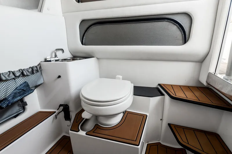 Slide: The Image of 2018 Nor-Tech 340 Sport Center Console boat interior with toilet and sink. - 13