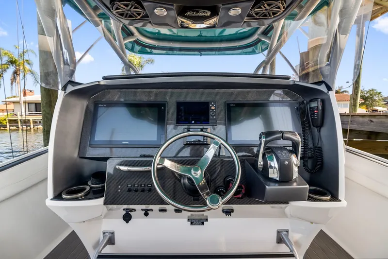 Slide: The Image of 2018 Nor-Tech 340 Sport Center Console helm with dual screens and modern controls. - 18