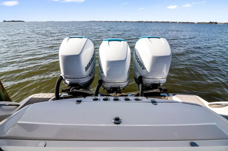 Slide: The Image of 2018 Nor-Tech 340 Sport Center Console with triple Mercury outboard engines on open water. - 25