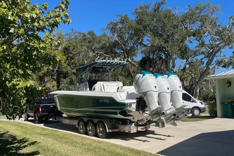 Slide: The Image of 2018 Nor-Tech 340 Sport Center Console boat on trailer, parked in driveway. - 27