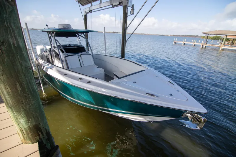 Slide: The Image of 2018 Nor-Tech 340 Sport Center Console boat docked by the water. - 3
