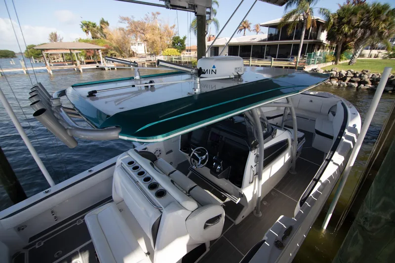 Slide: The Image of 2018 Nor-Tech 340 Sport Center Console boat docked, featuring sleek design and modern amenities. - 8