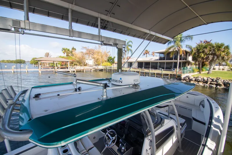 Slide: The Image of 2018 Nor-Tech 340 Sport Center Console boat docked by waterfront homes. - 9