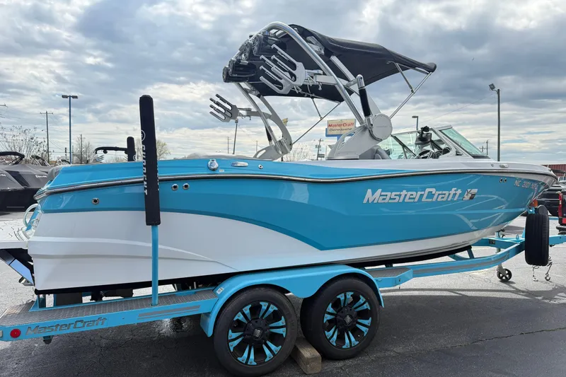 Slide: The Image of 2017 MasterCraft XT23 boat in blue and white on a matching trailer. - 2