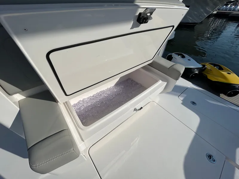 Slide: The Image of 2026 Scout 435 LXF boat with open storage compartment at dock. - 11